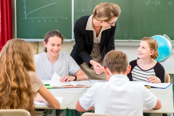 Teacher teaching students  geography lessons in school