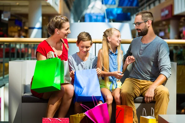 Family with kids shopping in mall having a break