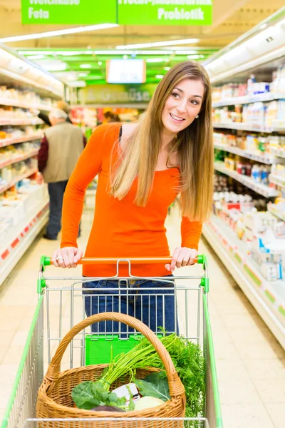 Woman with shopping cart in supermarket