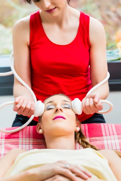 Woman having face massage in wellness spa