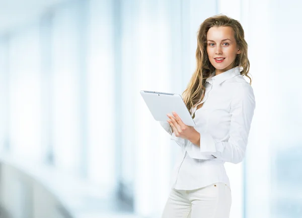 Modern business woman with tablet on the background of the office
