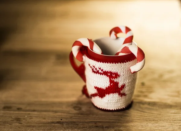 Insulated wool cloth mug with embroidered deer on the wooden table