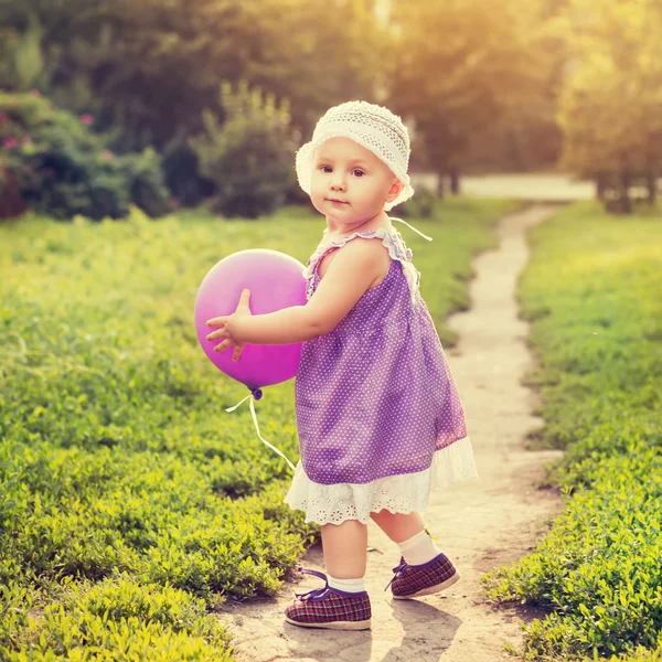Little girl with a purple balloon