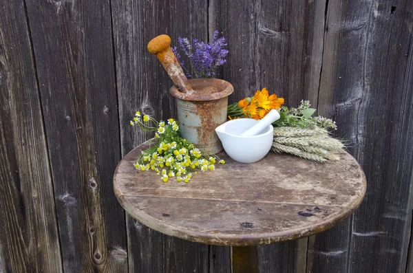 Mortars on old table and various medical herbal medicine flowers