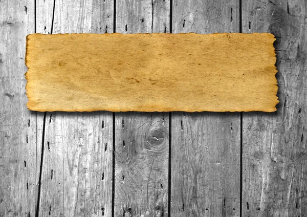 Vintage old grungy paper banner over ancient wood texture background