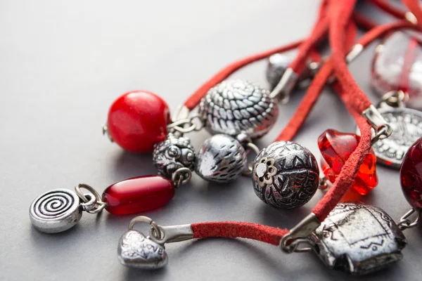 Close up of red glass beads and silver charms