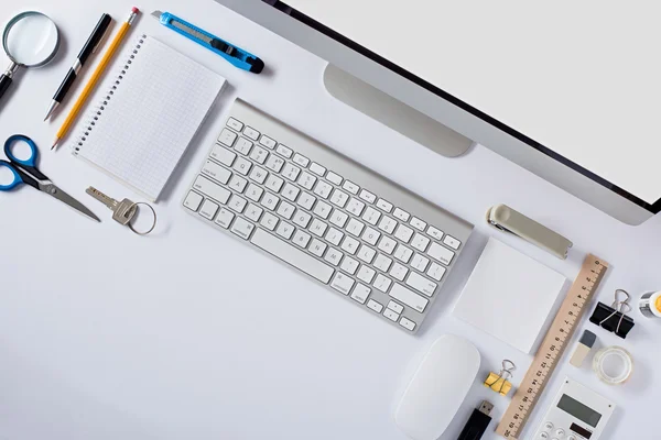 The white office table with stationery accessories, keyboard,computer mouse.