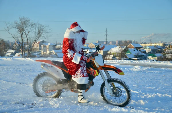 Santa Claus astride on the motocross bike