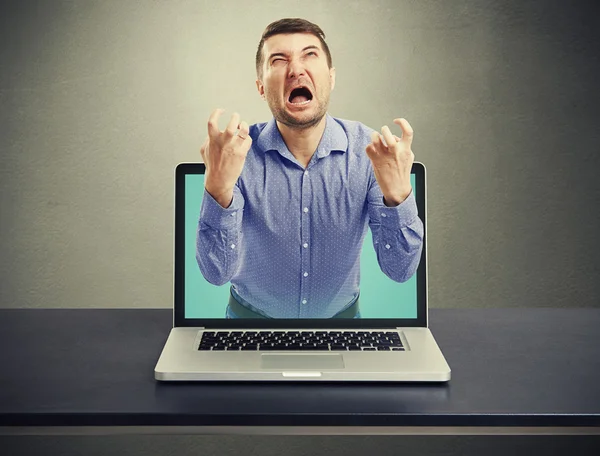 Emotional screaming man got out of the laptop