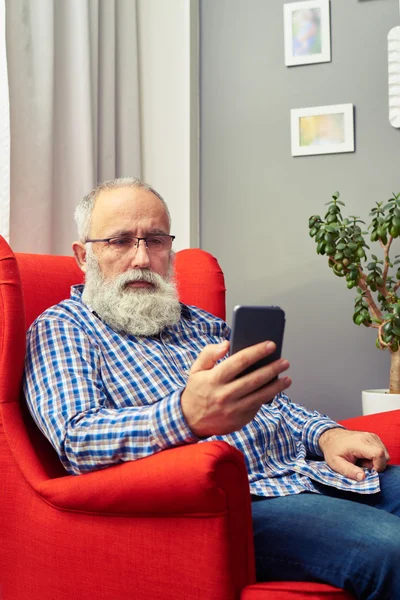 Bearded senior man with smartphone