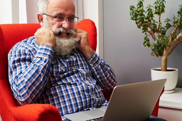 Man looking at laptop and tearing his beard