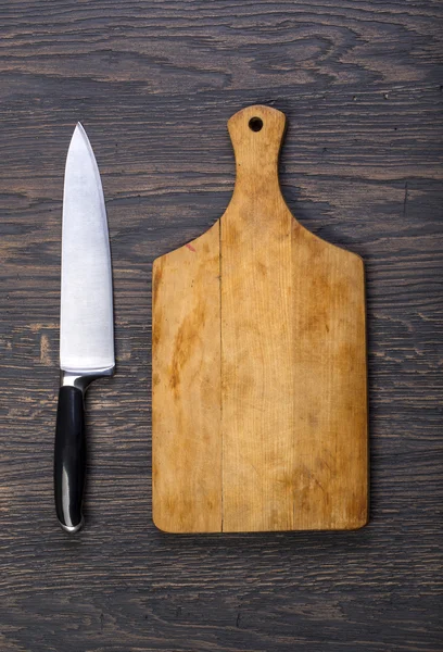 Empty chopping board with a knife