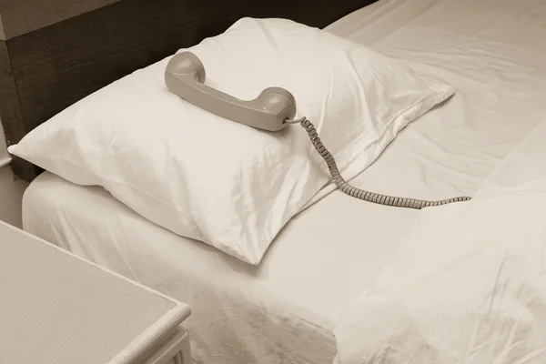 Old telephone on the bed in hotel