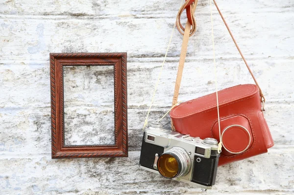 Old camera with a frame hanging on the wall