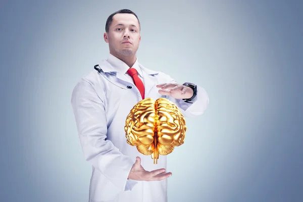 Doctor with stethoscope and golden brains on the hands. gray background. High resolution.