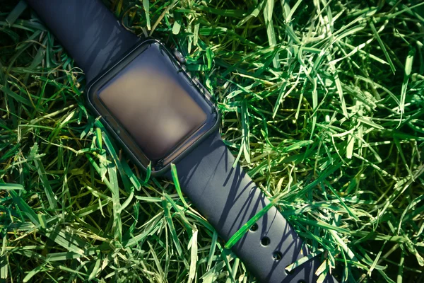 Mockup of Smart watch in green grass.