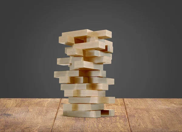 Blocks wood game  jenga  on wood floor black background.