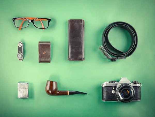 Set of Retro hipster mock up. Laptop, old camera, tablet and smoke pipe on green background. Filtered image