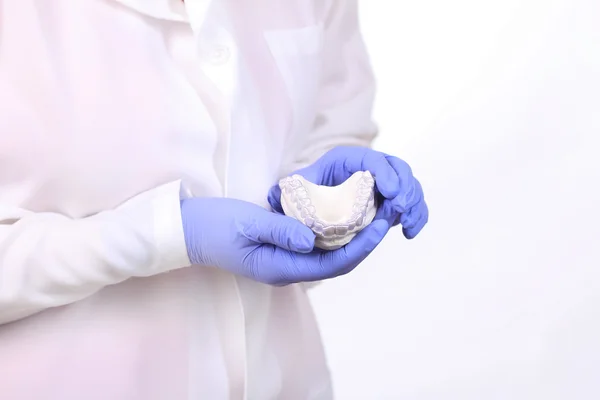 Close-up shot of doctors hands in gloves holding silicone mouth guard. Teeth care