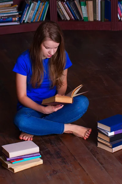 Girl sits on floor in the library