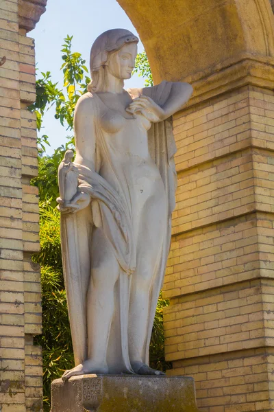 White stone sculpture of a woman with a little virgin in hand