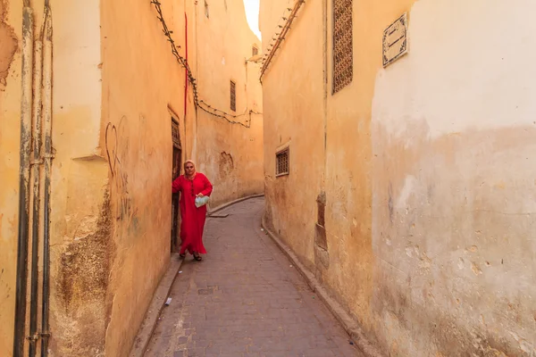 Woman walking out into a narrow street in the medina