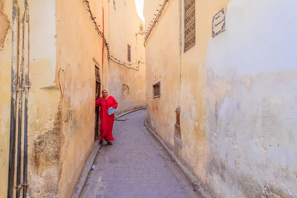 Woman walking out into a narrow street in the medina