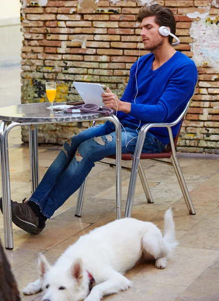 Young man with tablet pc touch with dog