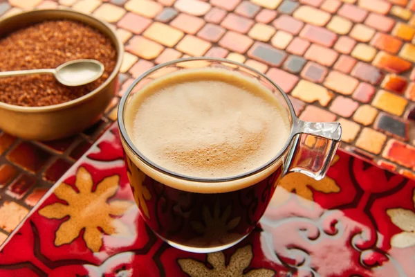 Coffee glass cup with cream on tiles red table