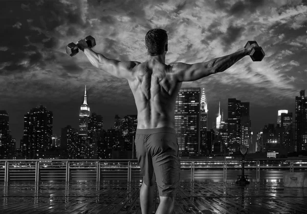Gym man rising hex dumbbells in New York city