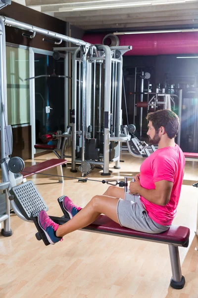 Seated cable row man rows at gym pulley machine