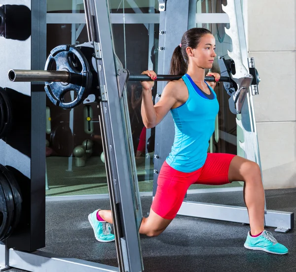 Girl squats in multipower squatting smith machine