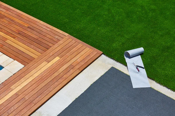 Artificial grass installation in deck garden with tools