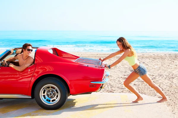 Girl pushing a broken car on the beach funny guy