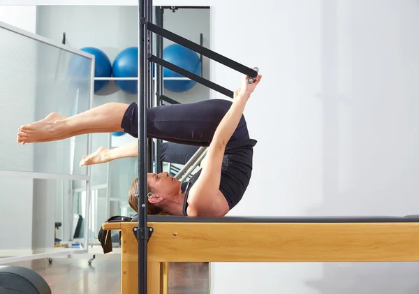 Pilates woman in reformer roll over exercise
