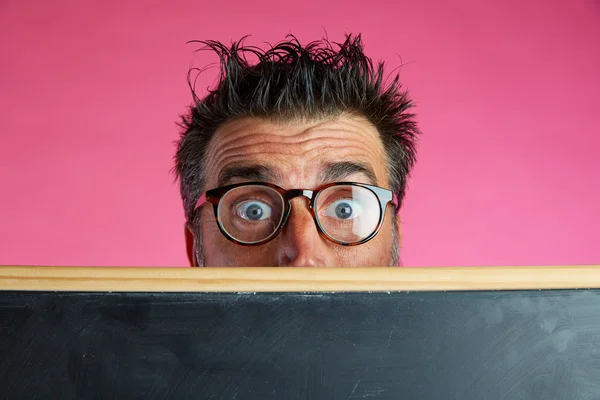 Nerd man crazy behind blackboard funny gesture