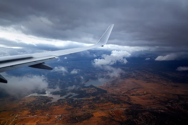 Aircraft wing in a cloudy stormy clouds sky