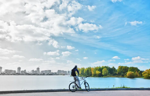 Cyclist between polluted city and nature