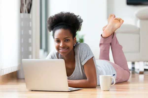 African American woman using a laptop in her living room - Black