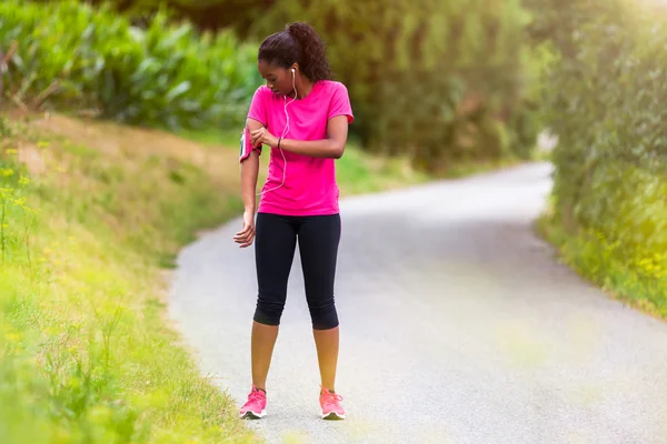 African american woman runner attaching music armband - Fitness