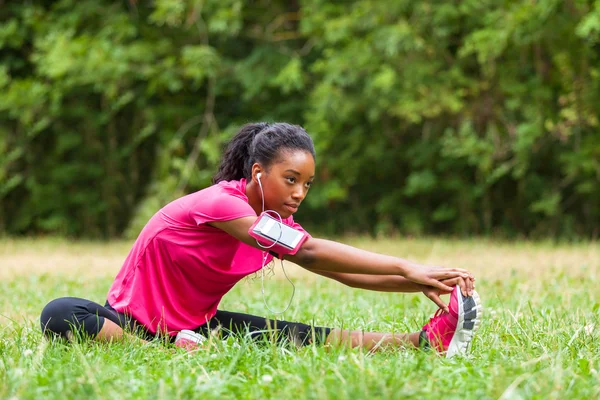 African american woman jogger stretching  - Fitness, people and