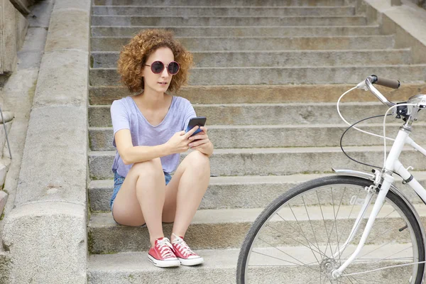Woman with mobile phone sitting on steps