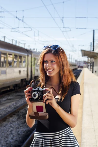 Young girl with  photographic camera in the city.