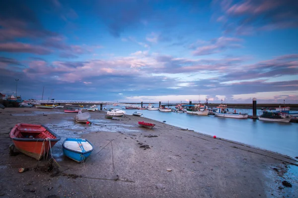 Traditional fishing boats anchored on low tide near Santa Luzia