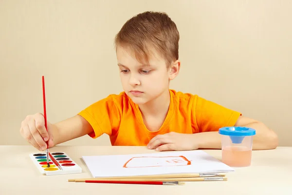 Young artist in orange shirt painting colors