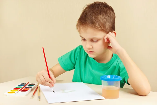 Little boy in green shirt painting colors