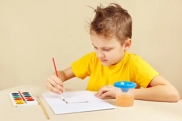 Little boy in yellow shirt painting colors