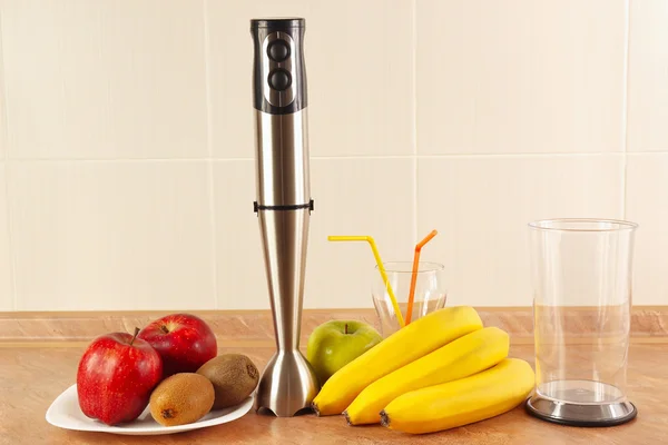 Fresh fruit, glasses and blender to prepare homemade smoothies