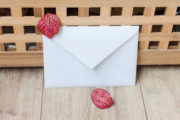 White envelope and red autumn leaves