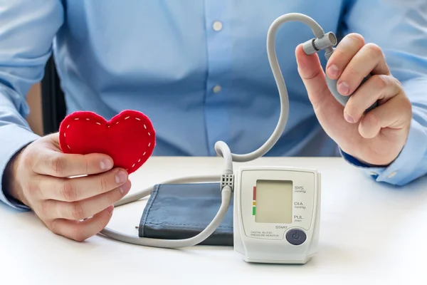 Doctor with digital blood pressure monitor